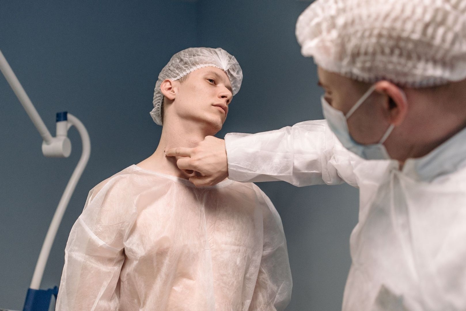 Vårdpersonal undersöker patientens hals inför eller efter kirurgi